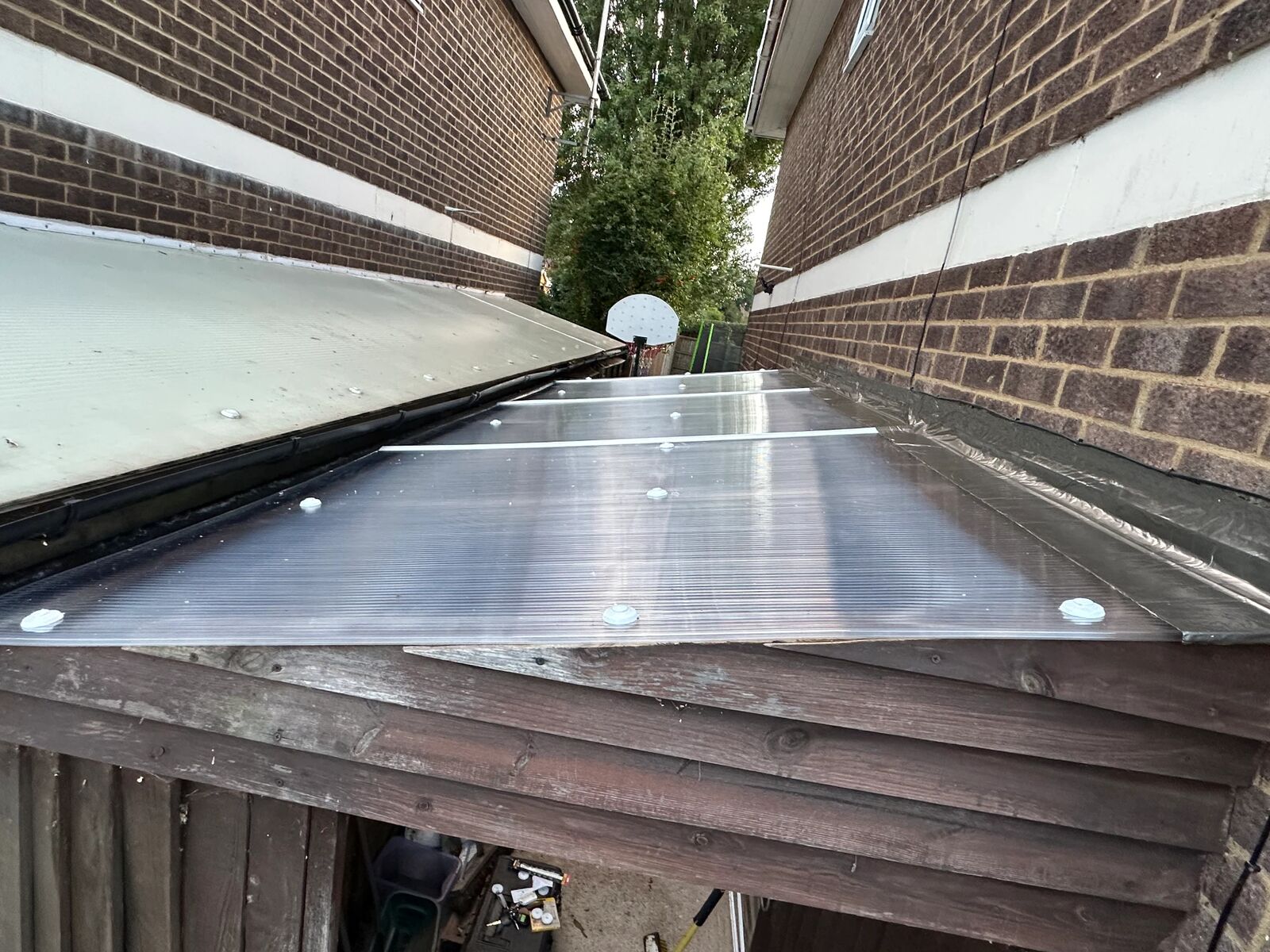 After: newly installed multiwall polycarbonate lean-to roof with white fixing buttons and joining profiles