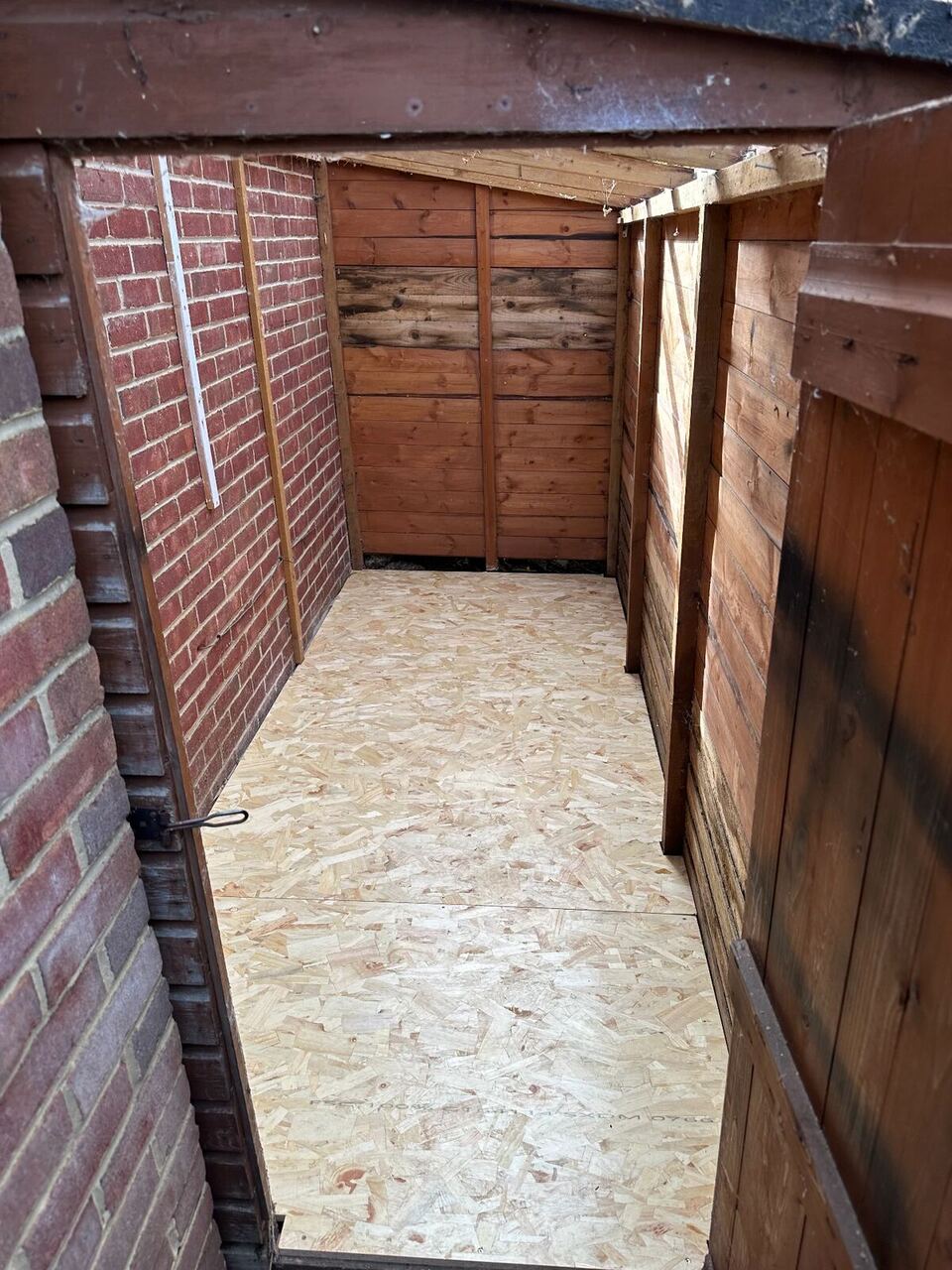 View through the lean-to doorway of the new OSB3 floor running to the back of the shed