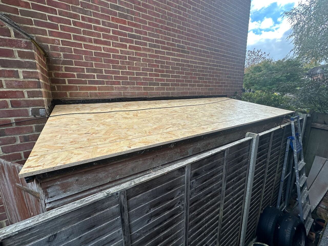 Lean-to roof covered with new light-coloured 18mm OSB3 boards before roofing felt was fitted