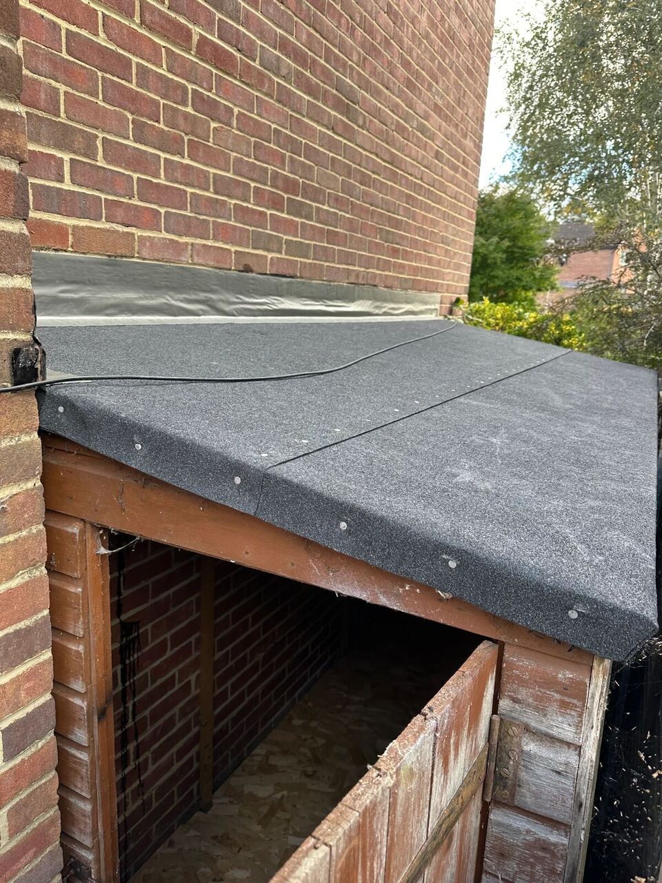 After: lean-to roof with new black roofing felt and silver Flashband sealing the joint with the brick wall