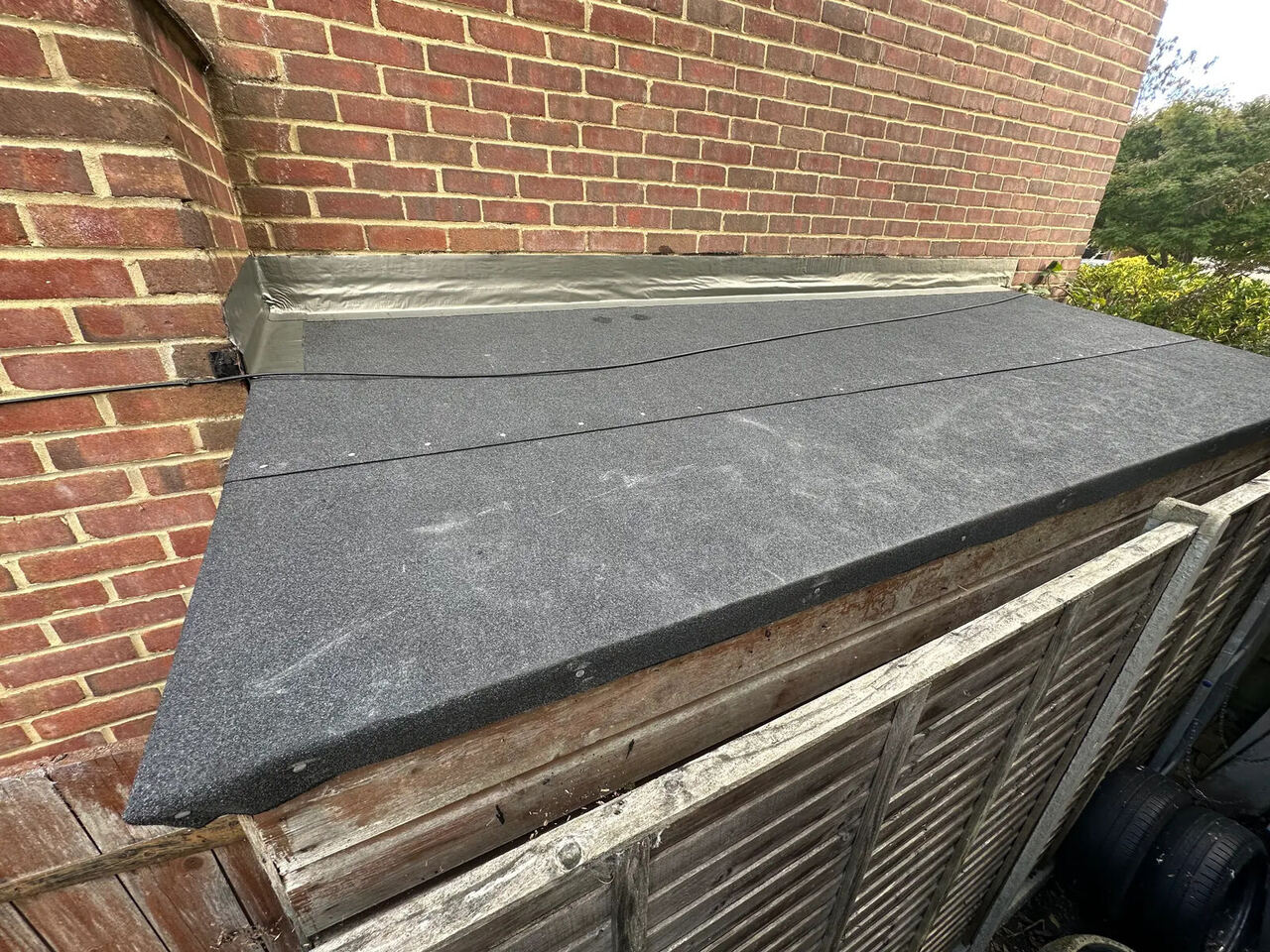Completed lean-to shed roof in Yateley with new black roofing felt and Flashband weatherproofing along the house wall